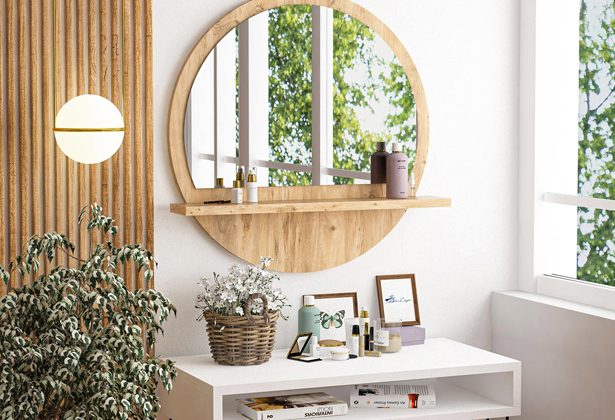 A round mirror with shelf above it and plants on the table.