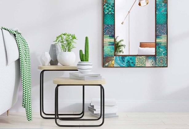 A mirror and two tables with plants on top of them.